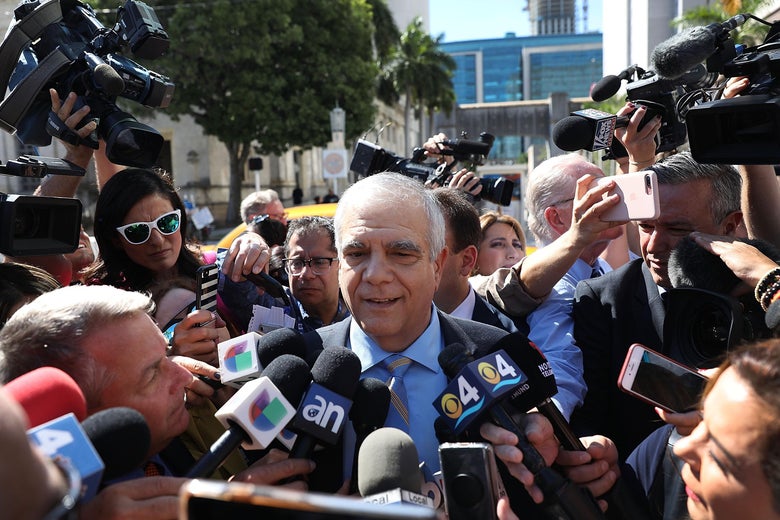 Daniel Aaronson surrounded by microphones from reporters.